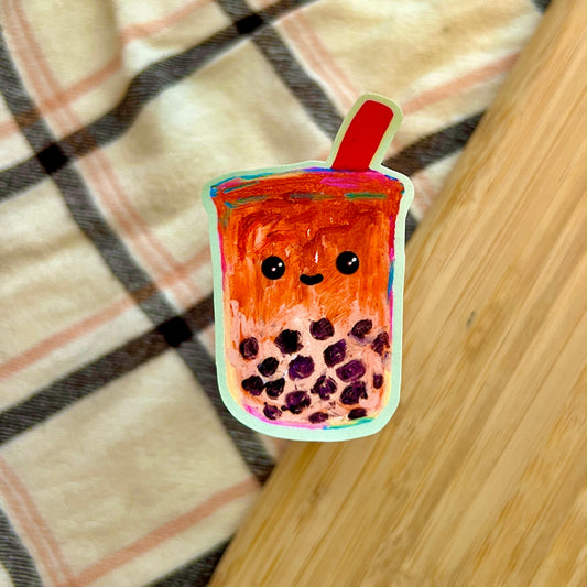 Colorful cartoon-style bubble tea with a straw on a checkered fabric background