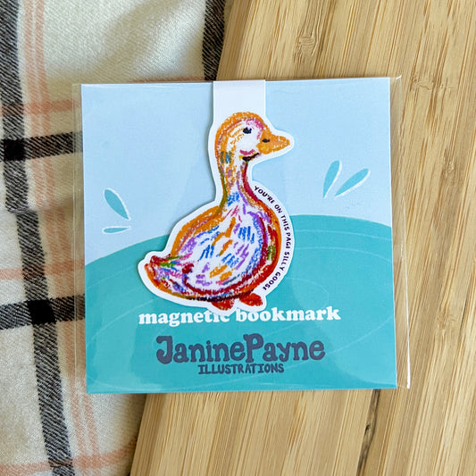 Magnetic bookmark with duck illustration by Janine Payne on a wooden surface