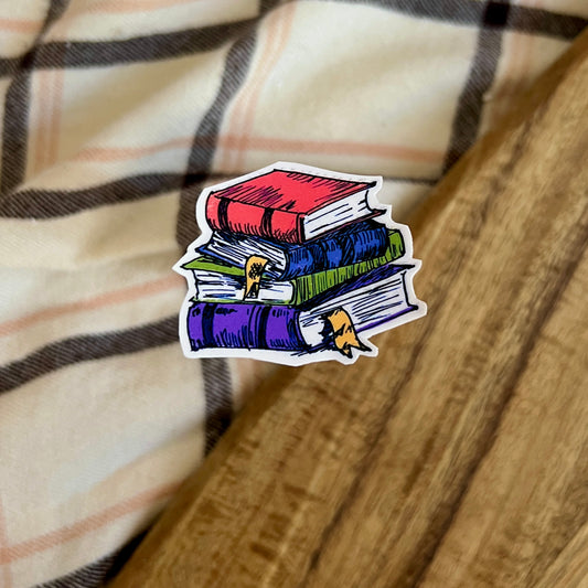 Sticker of a stack of books on a plaid fabric background