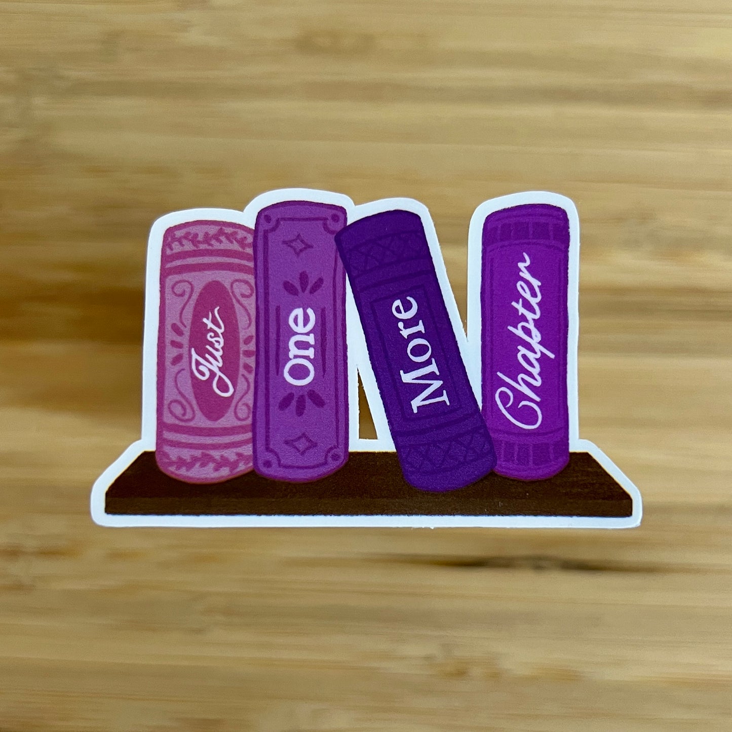 Four purple books with text on a wooden surface