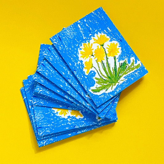 Stack of blue cards with yellow flower design on a yellow background