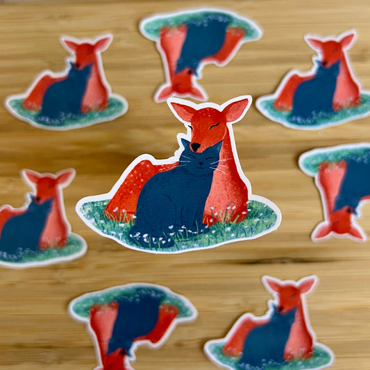 deer and cat stickers on a wooden surface