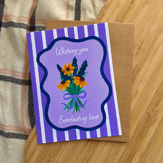 Greeting card with floral design and text on a wooden surface