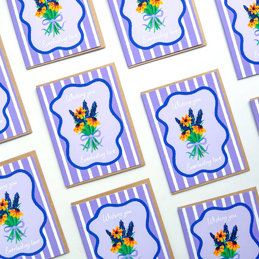 wedding cards with hand drawn flowers and text 'wishing you everlasting love' on a purple striped background with Kraft envelope