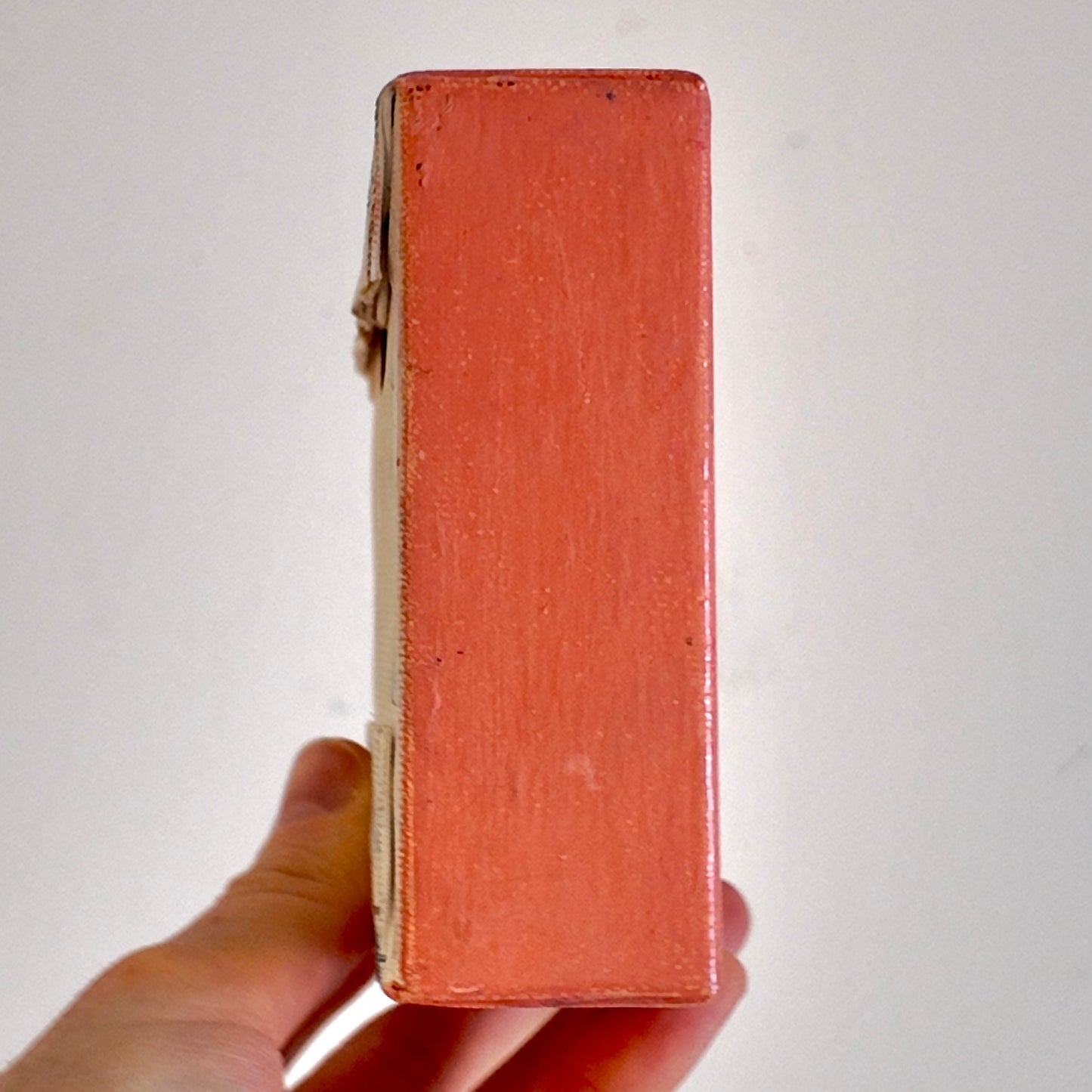 Hand holding a red leather wallet against a white background
