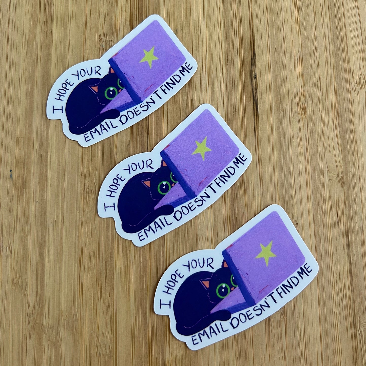 three stickers of cat behind laptop with text 'I hope your email doesn't find me'