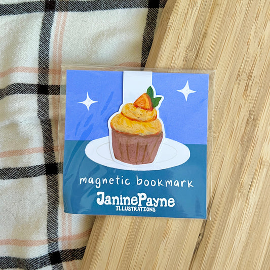 Magnetic bookmark with a cupcake illustration on a wooden surface