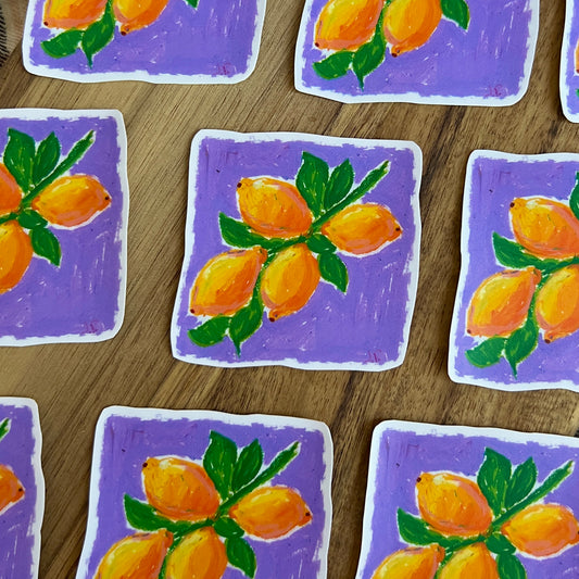 Stickers with painted lemons on a purple background arranged on a wooden surface.