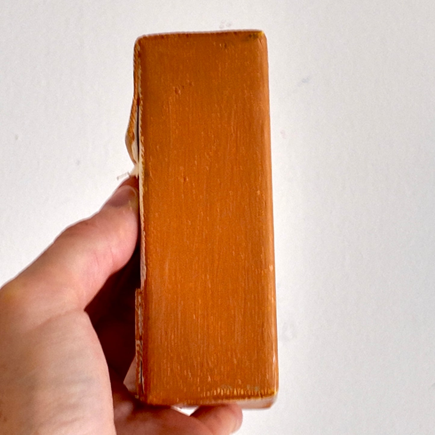 Hand holding a brown leather wallet against a white background
