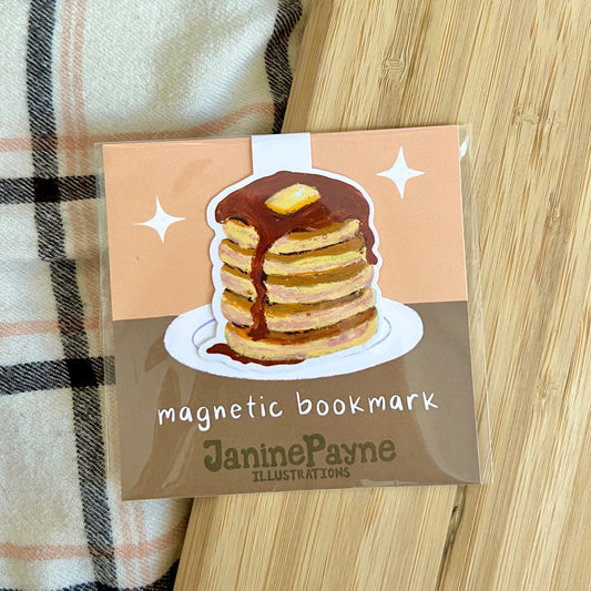 Magnetic bookmark with pancake illustration by Janine Payne on a wooden surface