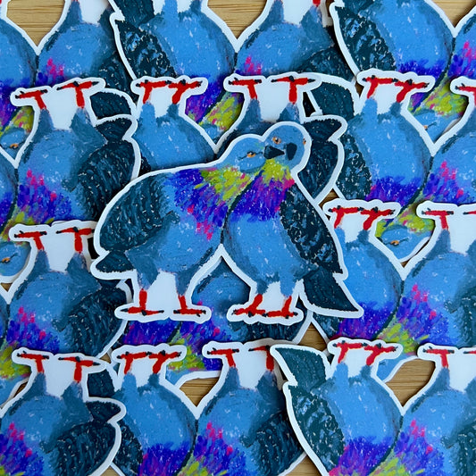 Stickers of blue birds with colorful accents on a wooden surface