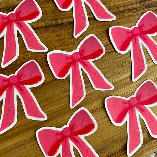 Pink bows with white edges on a wooden surface