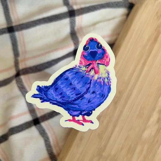 Colorful bird sticker on a checkered fabric background