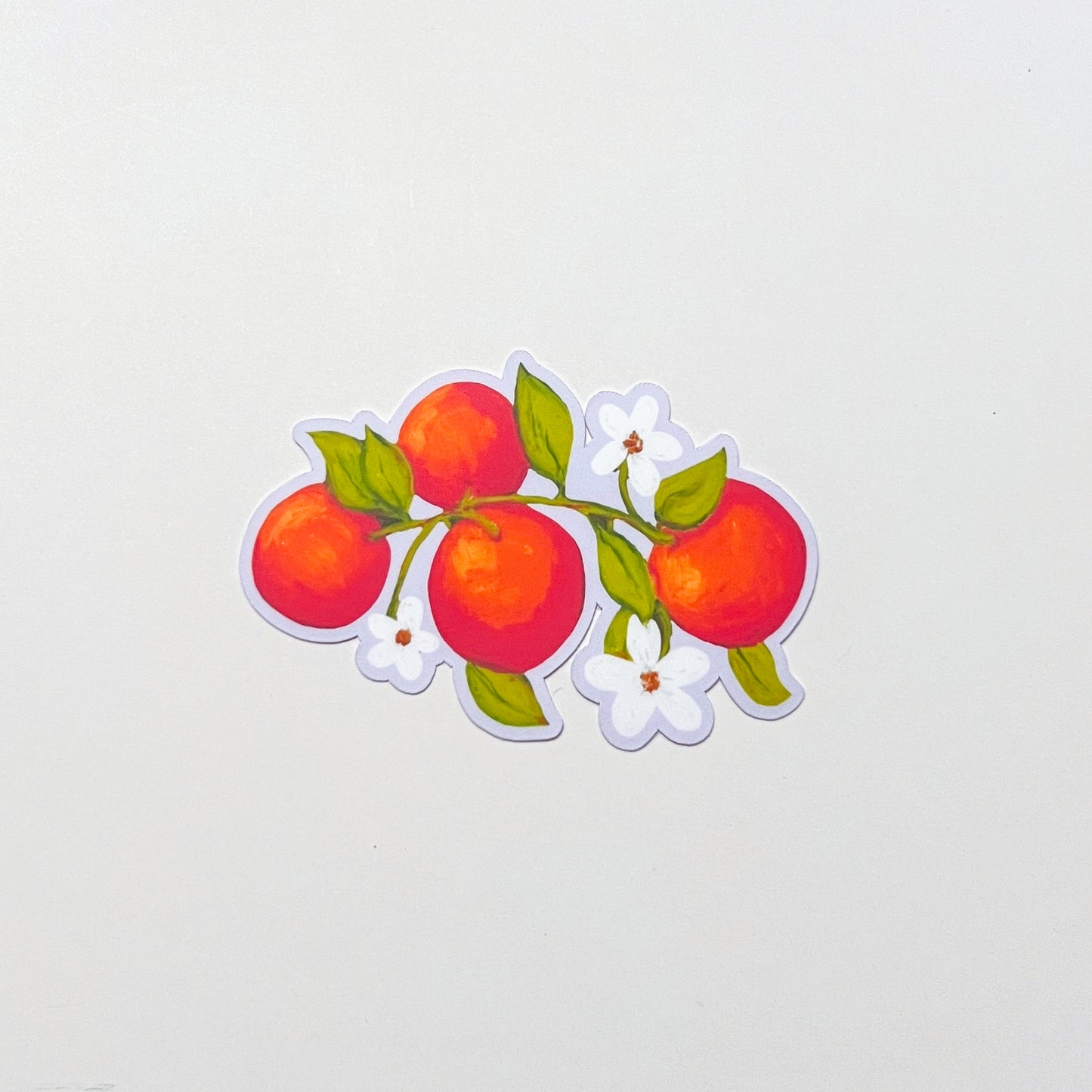 Sticker of oranges and leaves on a light gray background