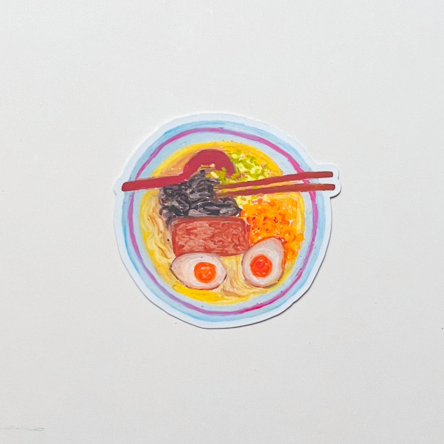 Sticker of a bowl of ramen with chopsticks on a white background