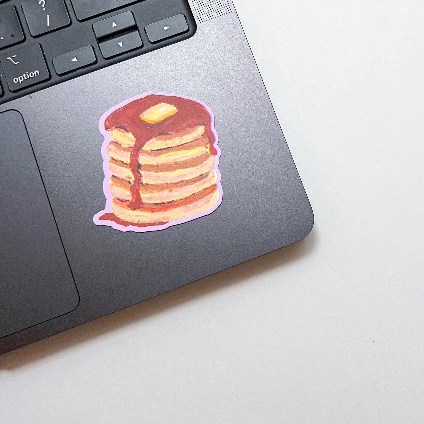 Laptop with a stack of pancakes sticker on the palm rest area