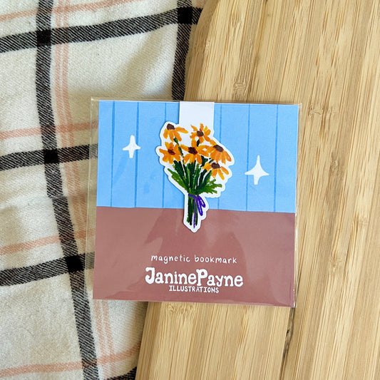 Magnetic bookmark with floral design and 'Janine Payne Illustrations' branding on a wooden surface.
