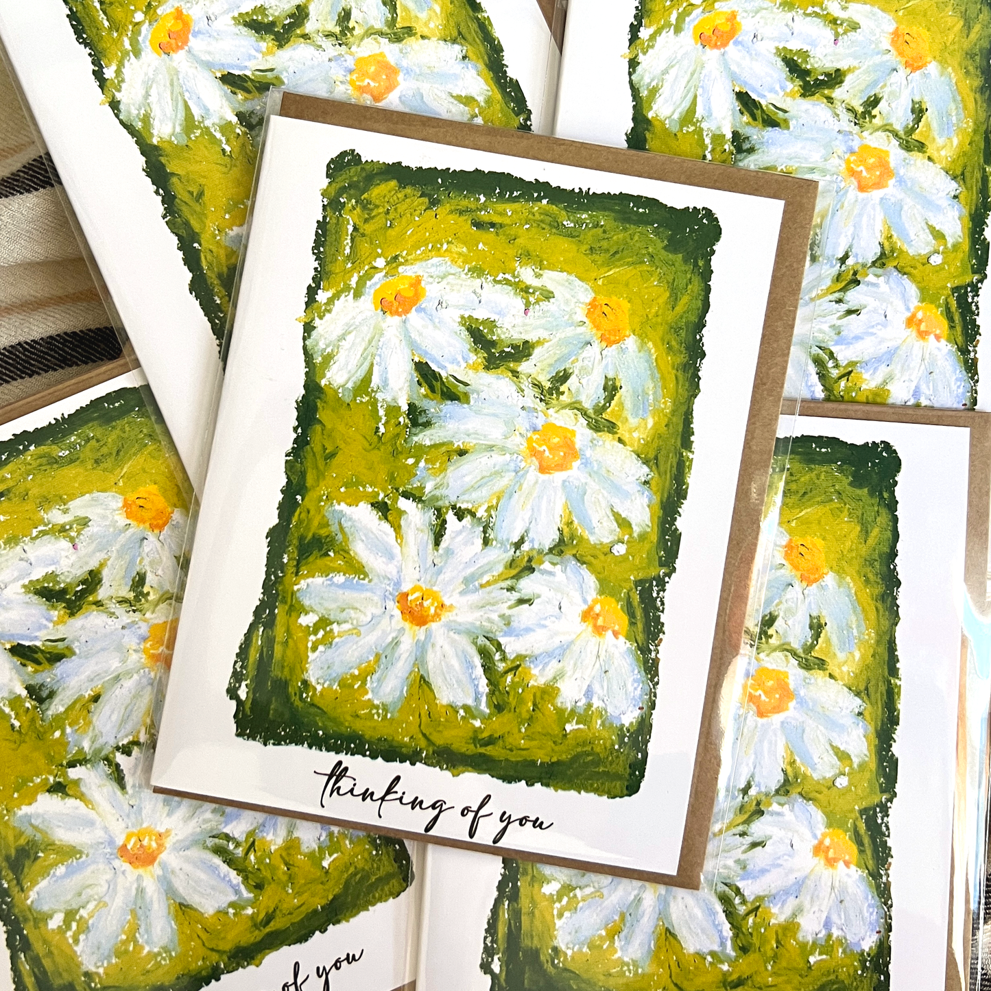 Greeting cards with daisy flower design and 'thinking of you' text.