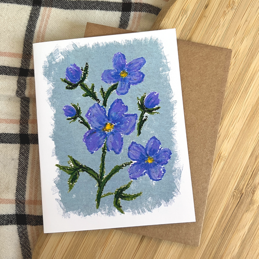 Card with a blue floral design on a wooden surface