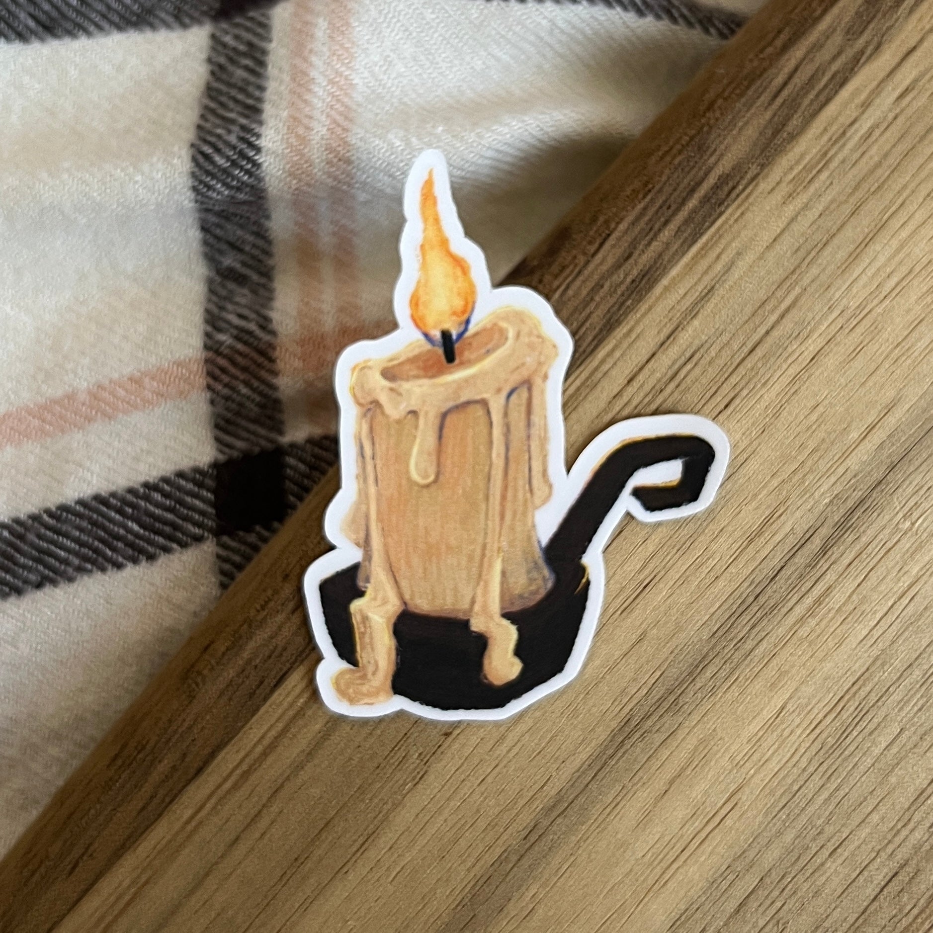 Sticker of a candle with a flame on a wooden surface