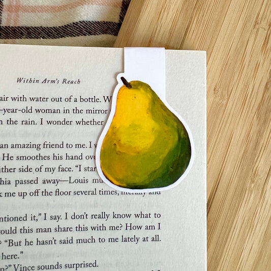 Pear-shaped bookmarker on a book with a wooden surface underneath