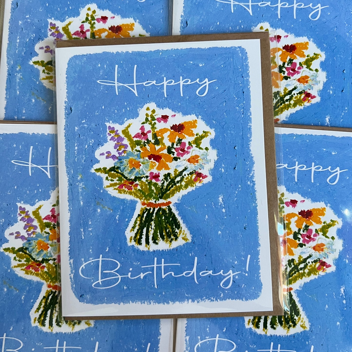 Birthday card with floral design and 'Happy Birthday!' text on a blue background