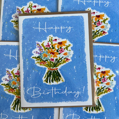 Birthday card with floral design and 'Happy Birthday!' text on a blue background
