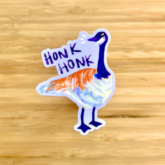 Sticker of a goose with 'Honk Honk' text on a wooden surface