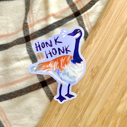 Sticker of a goose with 'Honk Honk' text on a plaid fabric background
