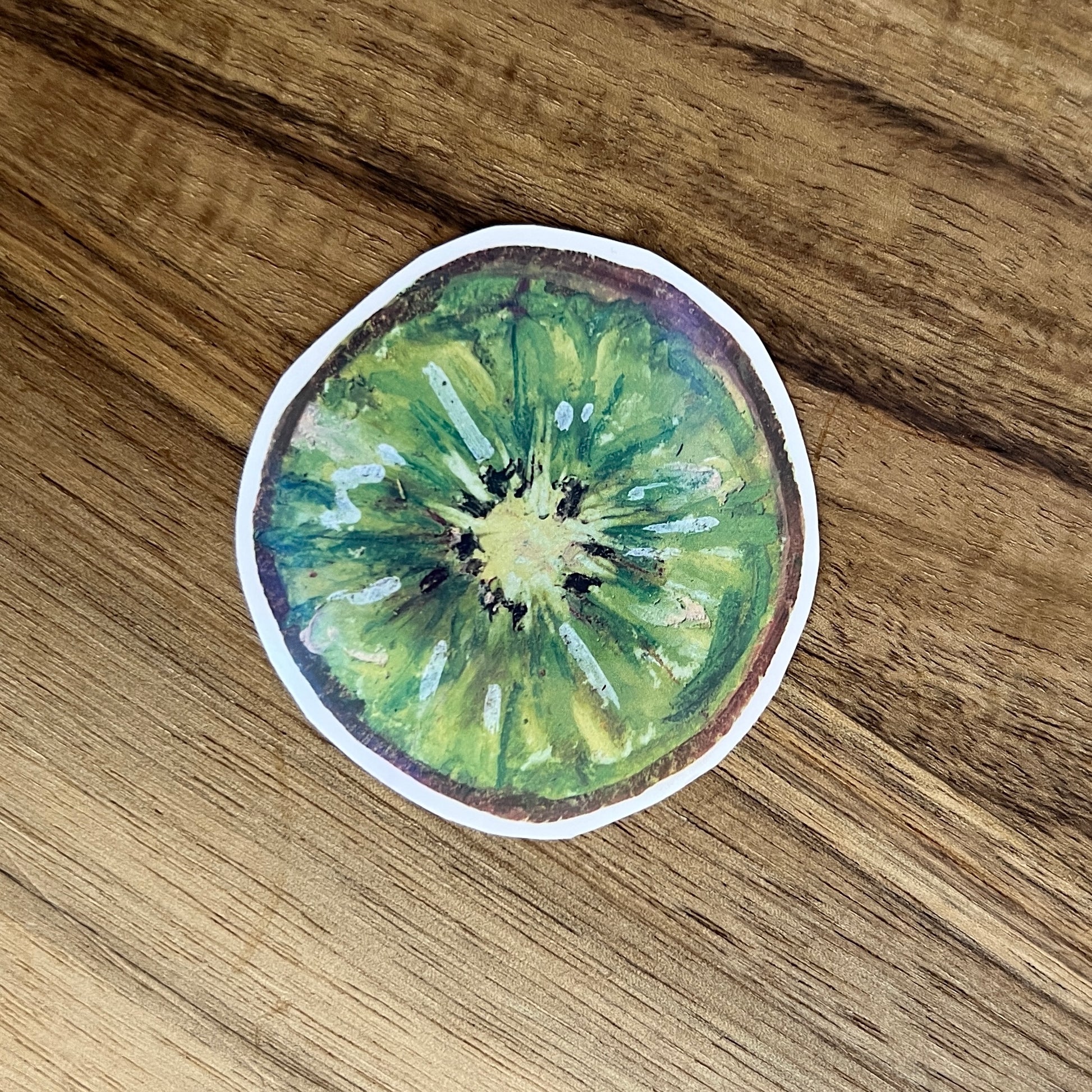 Sticker of a kiwi slice on a wooden surface