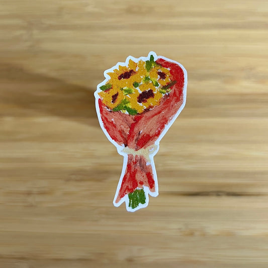 Sticker of a bouquet with yellow flowers and red wrap on a wooden surface