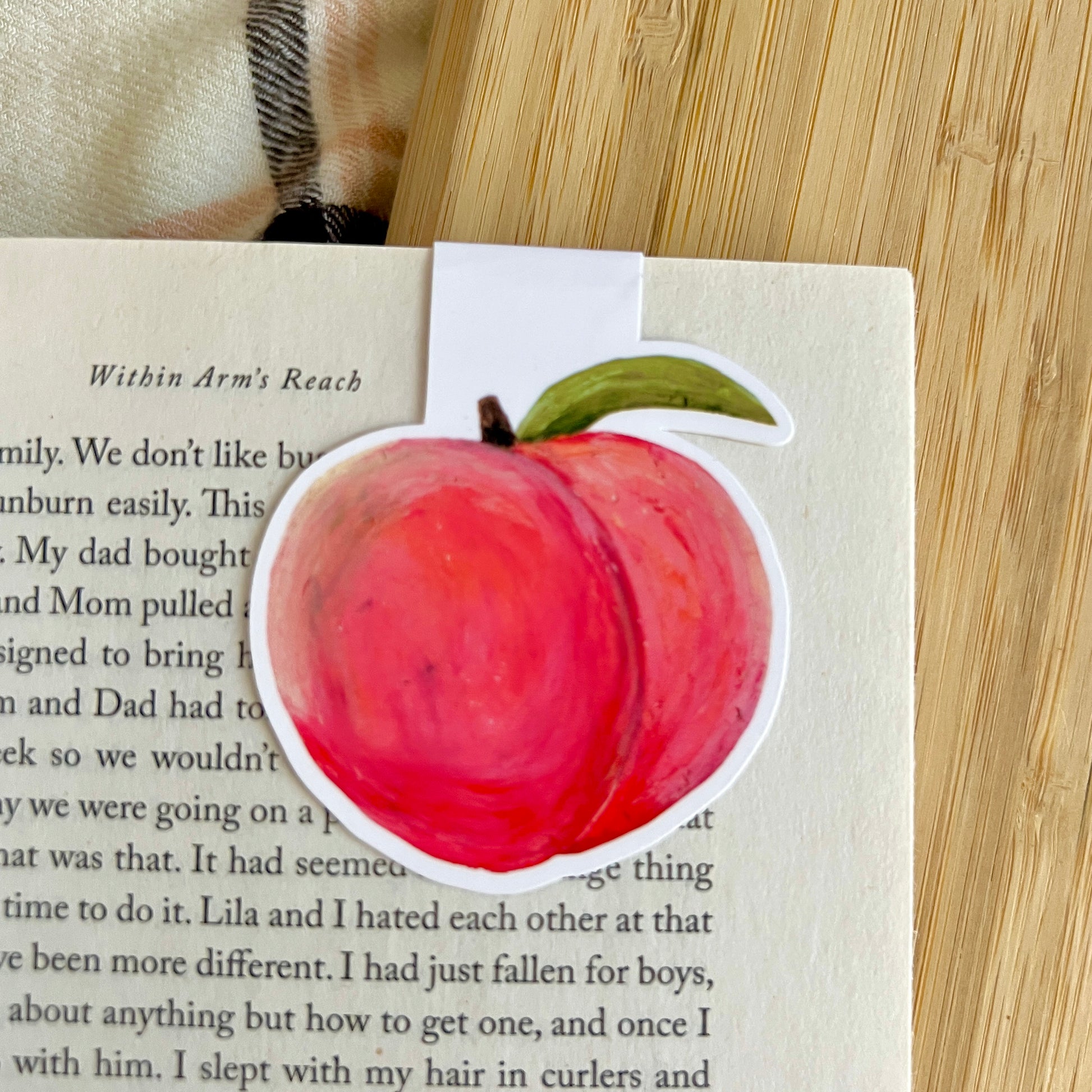 Peach bookmark on a book with a wooden surface underneath