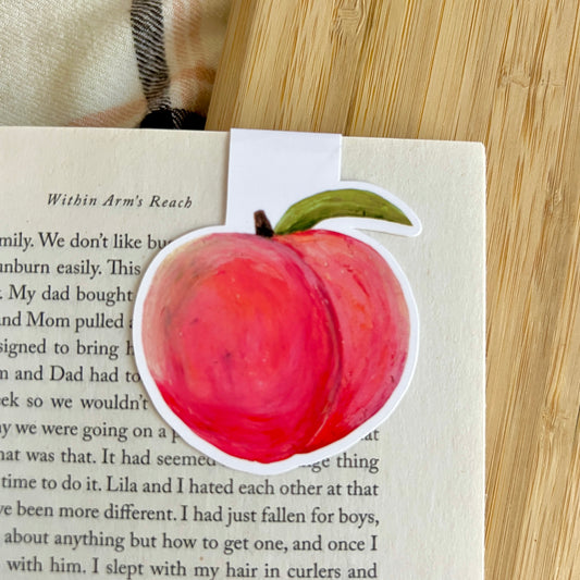 Peach bookmark on a book with a wooden surface underneath