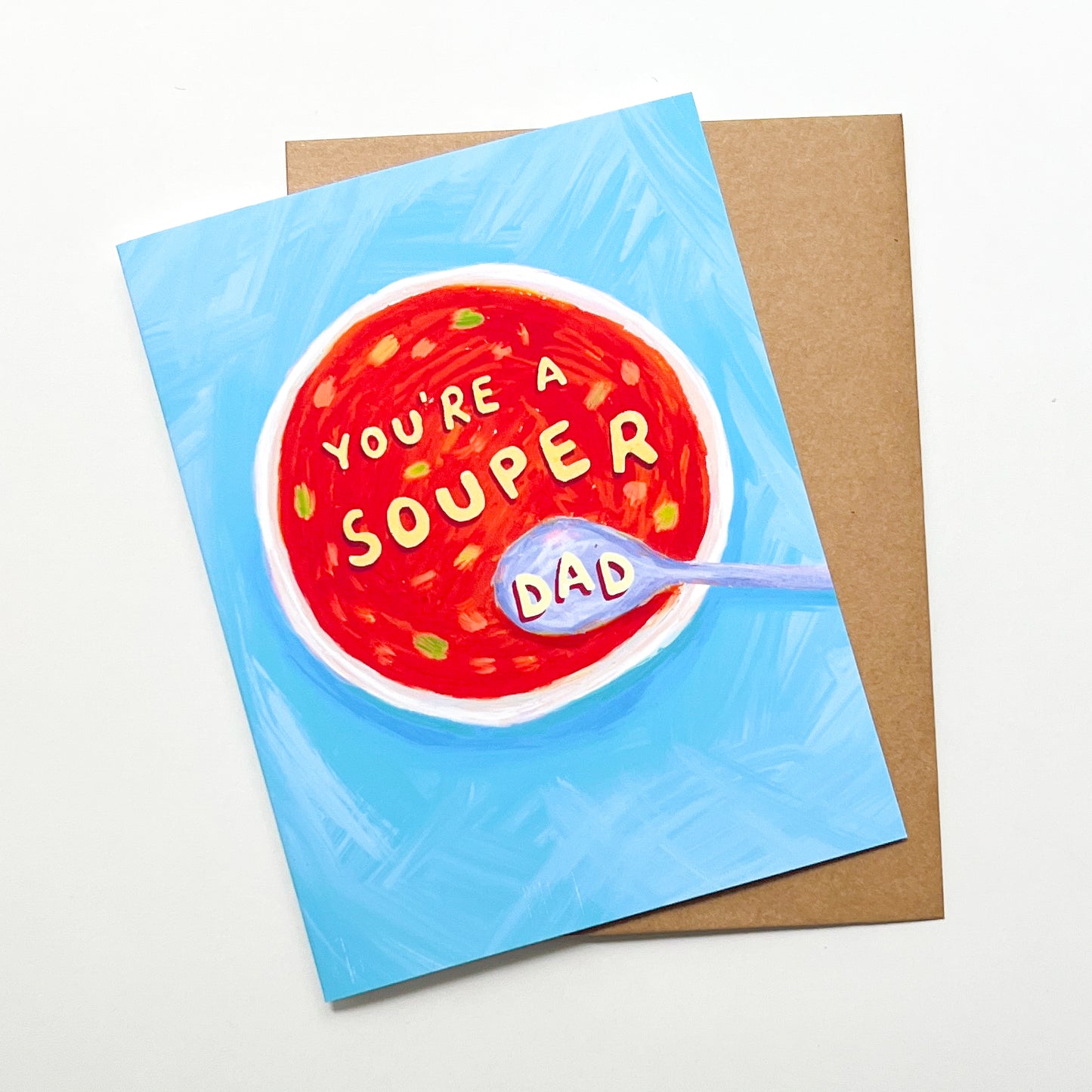 Greeting card with a bowl of soup design and 'You're a souper dad' text on a blue background.