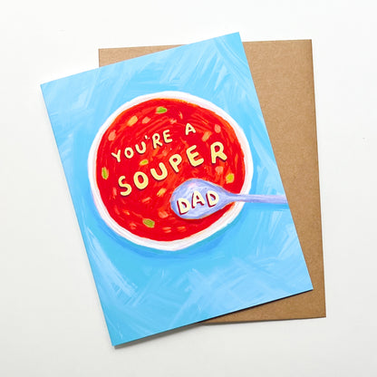 Greeting card with a bowl of soup design and 'You're a souper dad' text on a blue background.