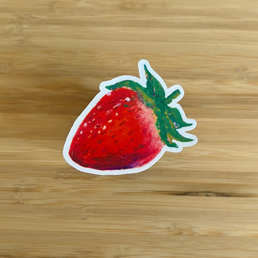 Strawberry-shaped sticker on a wooden surface
