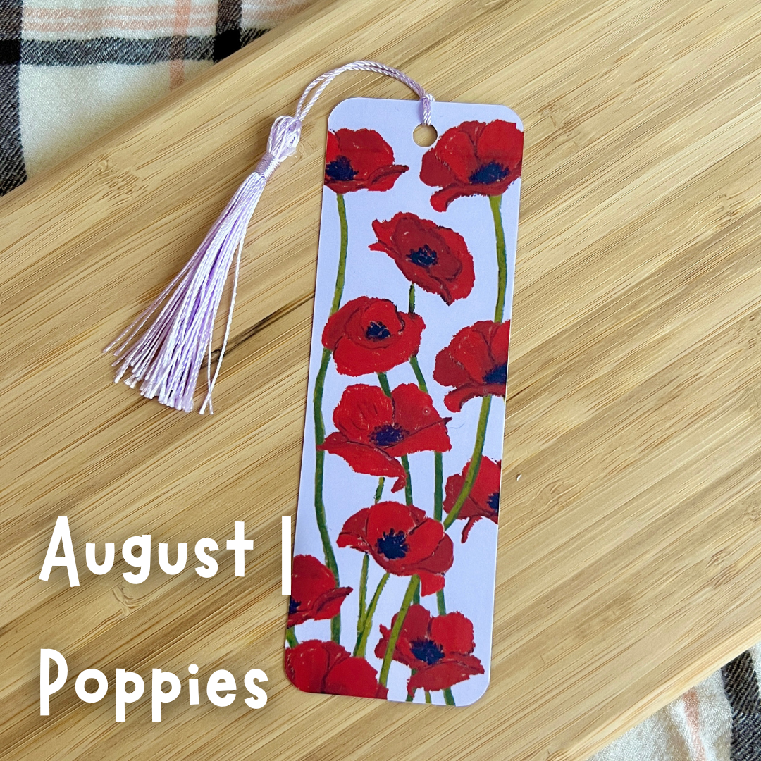 Bookmark with red poppies design on a wooden surface, featuring the text 'August Poppies'.
