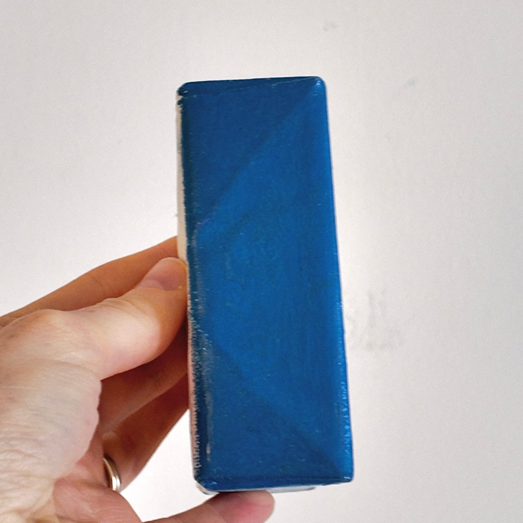 hand holding a dark blue canvas side profile
