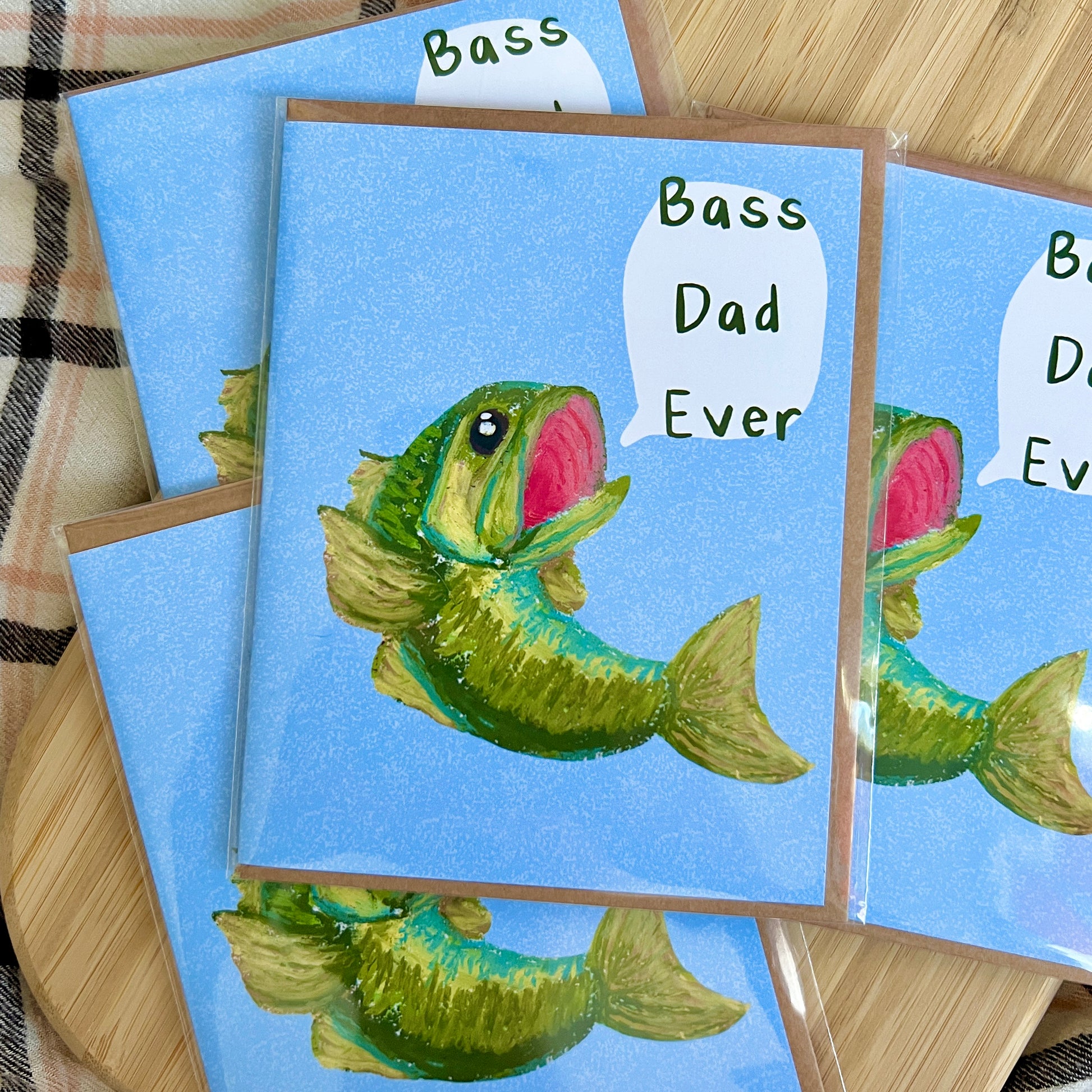 Set of greeting cards with a fish illustration and 'Bass Dad Ever' text on a blue background.