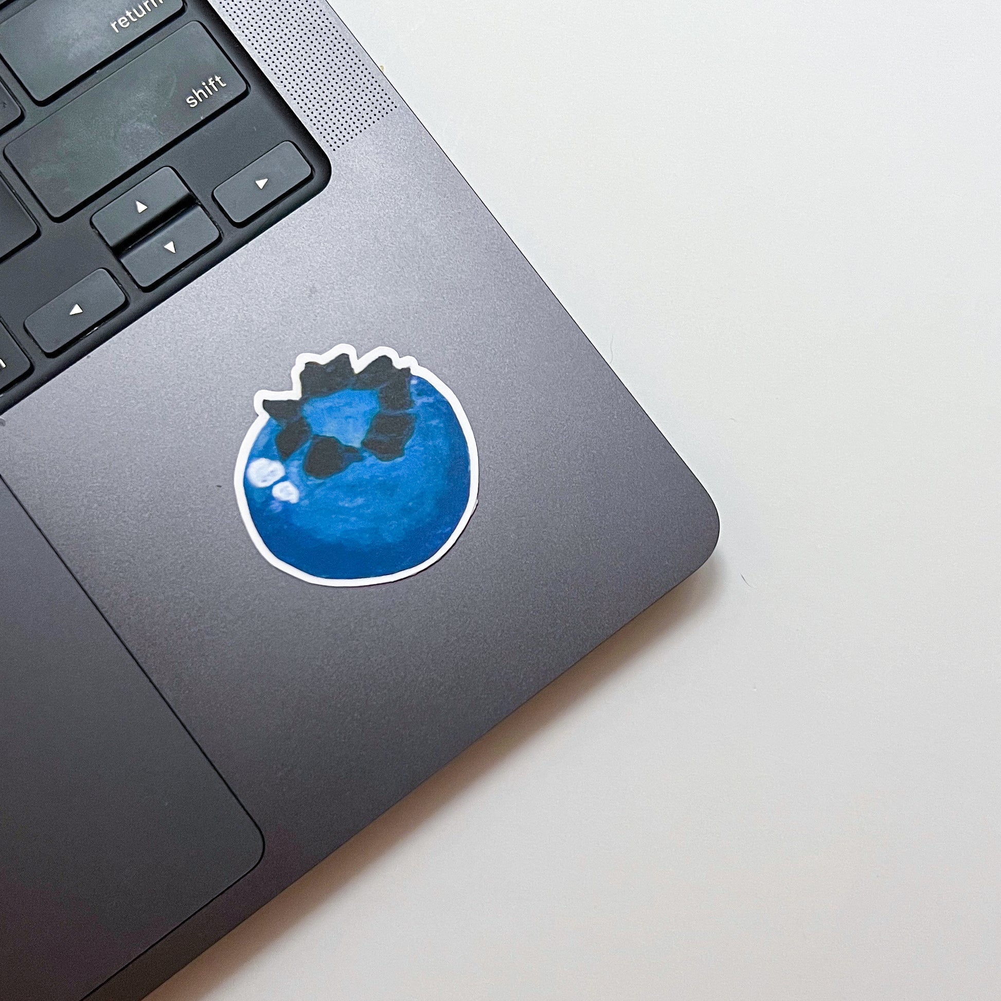 Laptop with a blue berry sticker on the palm rest area