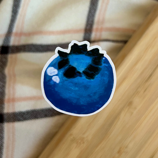 Blueberry-shaped sticker on a plaid fabric background