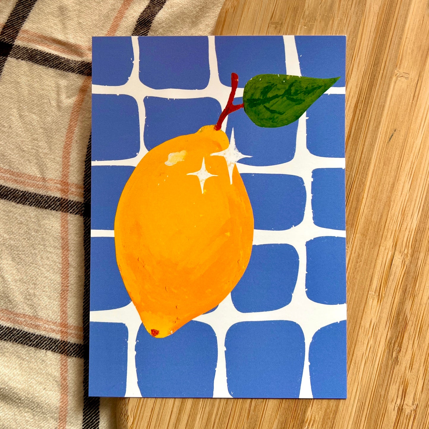 illustrated lemon with blue checkered background on wooden and plaid surface