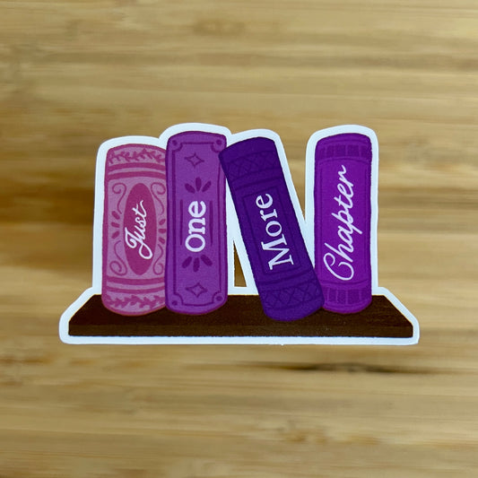 Four purple books with text on a wooden surface