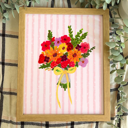 Framed artwork of a colorful bouquet of flowers on a pink striped background