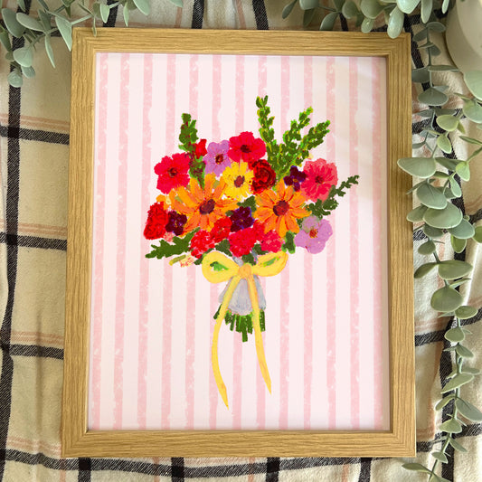 Framed artwork of a colorful bouquet of flowers on a pink striped background