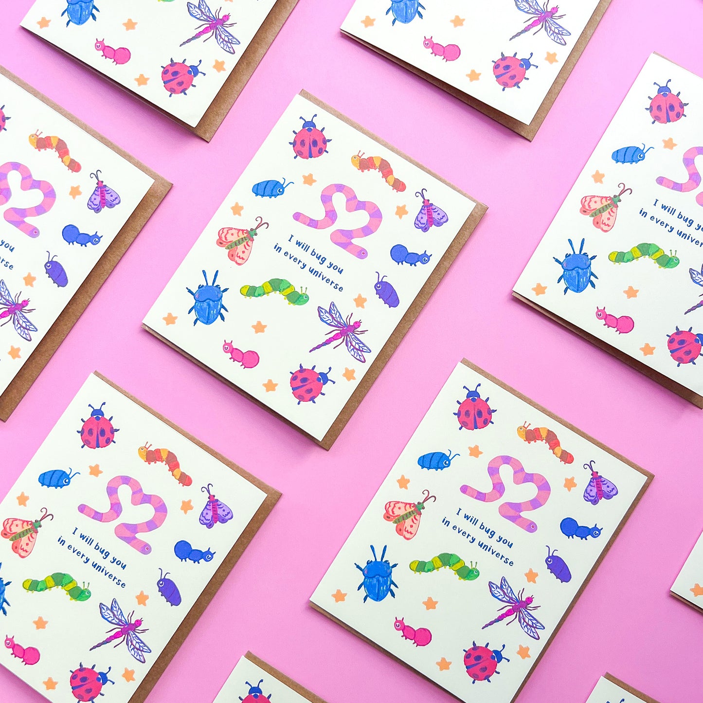 pattern of greeting cards with an illustration of various bugs and text 'I will bug you in every universe' on pink background