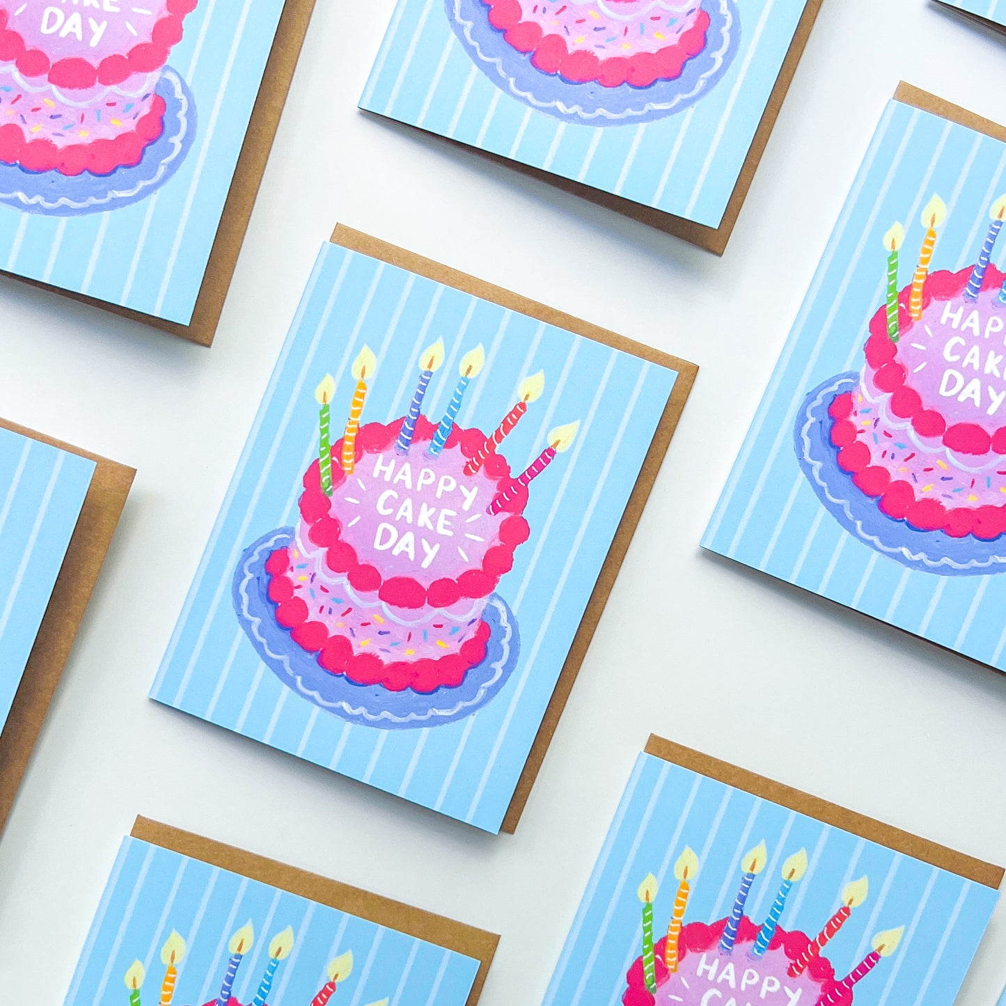 pattern of birthday cards with cake illustration and text 'happy cake day' against a white background