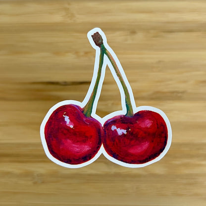 Sticker of two cherries on a wooden background