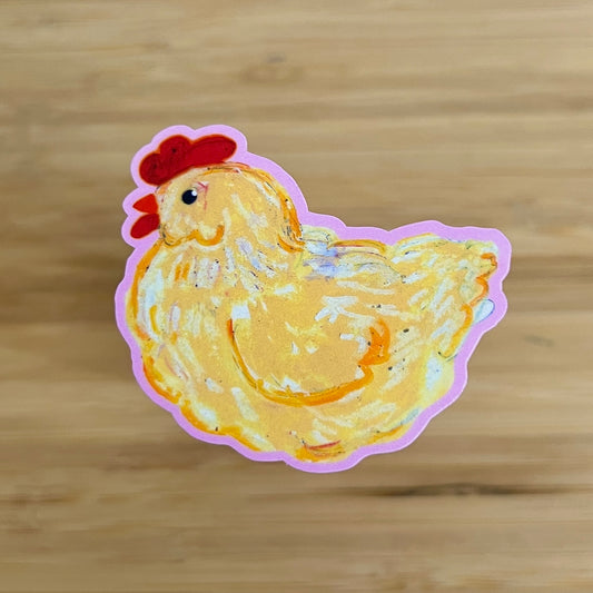 Sticker of a yellow chicken on a wooden surface