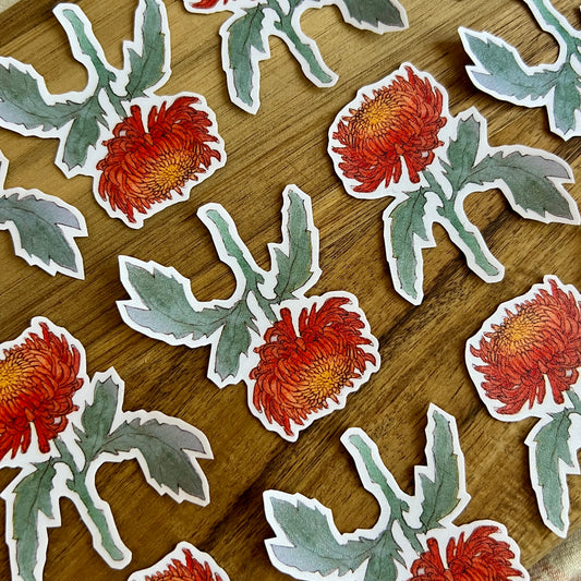 Stickers of red flowers with green leaves on a wooden surface
